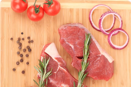 Raw steaks on cutting board. Located on the whole background.