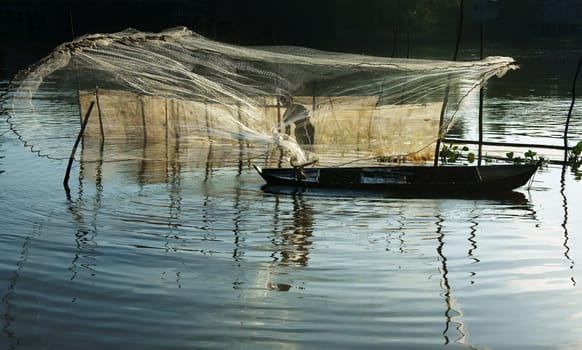 Beautiful landcape with reflection of silhouette of fisherman cast a net on river surface water