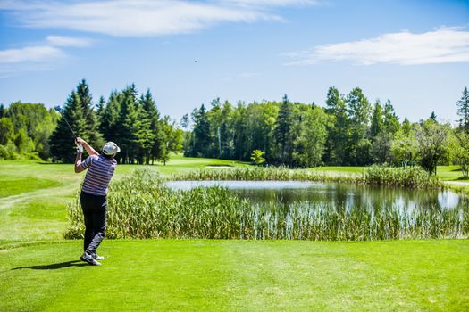 Mature Golfer on a Golf Course Taking a Swing on the Start.