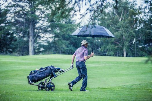 Golfer on a Rainy Day Leaving the Golf Course (the game is annulled because of the storm)