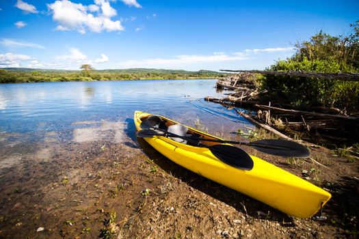 Yellow Kayak Ready to be Used on the Cost of a River