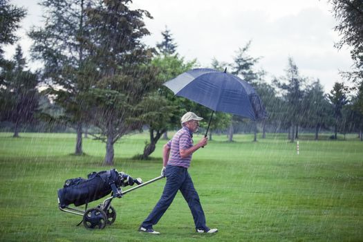 Golfer on a Rainy Day Leaving the Golf Course (the game is annulled because of the storm)