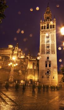 Giralda Spire, Bell Tower, Seville Cathedral, Rainy Night, Seville, Andalusia Spain.  Built in the 1500s.  Largest Gothic Cathedral in the World and Third Largest Church in the World.  Burial Place of Christopher Columbus.  Giralda is a former minaret converted into a bell tower