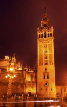 Giralda Spire, Bell Tower, Seville Cathedral, Rainy Night, Car Trails, Seville, Andalusia Spain.  Built in the 1500s.  Largest Gothic Cathedral in the World and Third Largest Church in the World.  Burial Place of Christopher Columbus.  Giralda is a former minaret converted into a bell tower