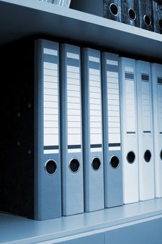 Folders for documents on a book shelf at office