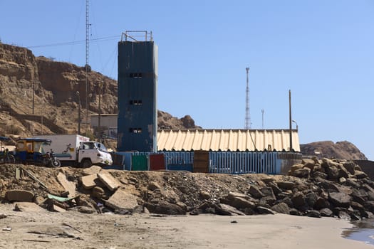 MANCORA, PERU - AUGUST 17, 2013: Entrance to the harbor and fish market of Mancora and place where fish get packaged and put on trucks on August 17, 2013 in Mancora, Peru. Mancora is a small town in Northern Peru that lives from fishing and tourism.  