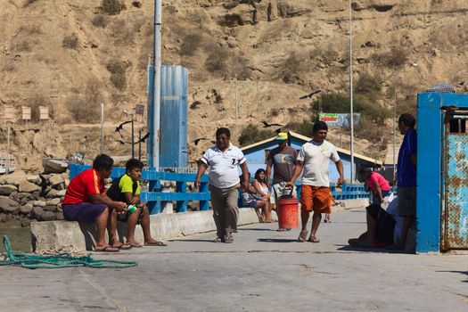 MANCORA, PERU - AUGUST 17, 2013: Unidentified people on the quay of the fishing harbor on August 17, 2013 in Mancora, Peru. Mancora is a small town in Northern Peru living from fishing and tourism.