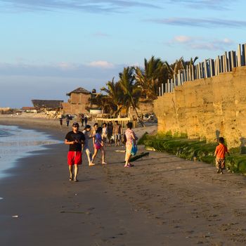 MANCORA, PERU - AUGUST 17, 2013: Unidentified people on the sandy beach on August 17, 2013 in Mancora, Peru. The small Northern Peruvian town of Mancora is a popular beach town and lives from tourism and fishing.