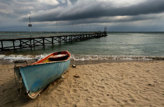 Autumn beach with boat and quay at the Black Sea shore of Bulgaria