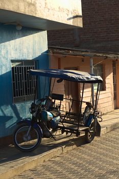 MANCORA, PERU - AUGUST 17, 2013: Mototaxi parking on sidewalk on August 17, 2013 in Mancora, Peru. Mototaxis (locally called Tuktuk) are a common means of transport in this small Northern Peruvian town.