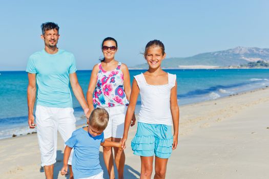 Family of four having fun on tropical beach