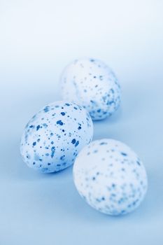 Three pale blue speckled painted easter eggs