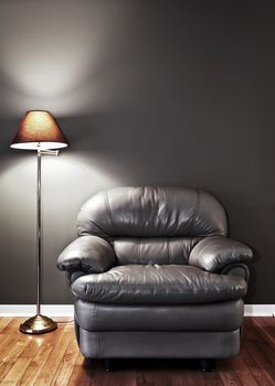 Leather chair and floor lamp against dark wall