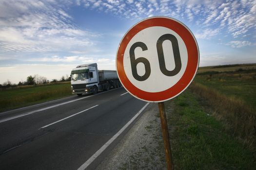 road sign speed limit sixty under cloudy blue sky