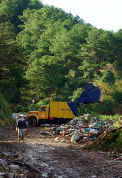 Garbage truck empty out the rubbish at dumping ground. Dalat, Viet Nam- September 05, 2013
