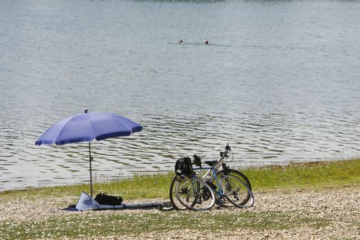 sunshade umbrella on lake Beach and two bicycle