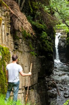 Hiker Looking at the Waterfall in the Wild Nature on a Rainy Day