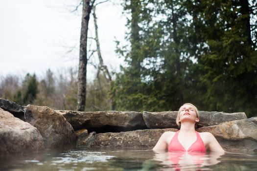 Young Woman Relaxing in a Outdoor Nordic Spa, in the forest.