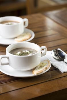 Vertical shot of two cups of mushroom soup ready to be served.