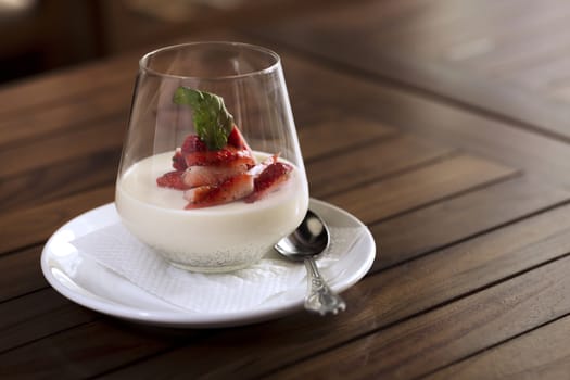 A strawberry dessert in a glass ready to be served.