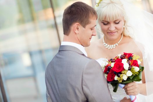 bride and groom by the glass wall 