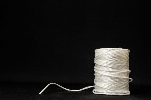 Roll of White Twine on a Black Background