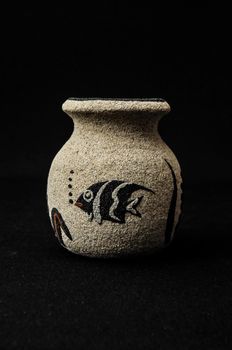 Colorful designed clay vase over a Black background