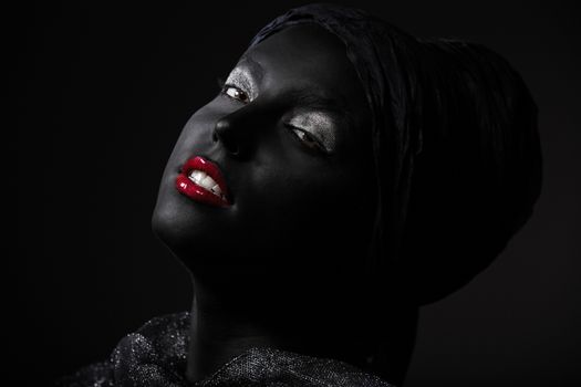 Woman with black skin in traditional turban. Studio shot