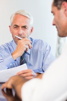 Two businessmen doing paperwork at desk in the office