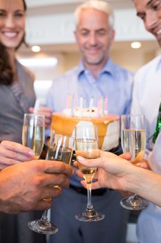 Closeup mid section of people with champagne flutes and cake at the bar
