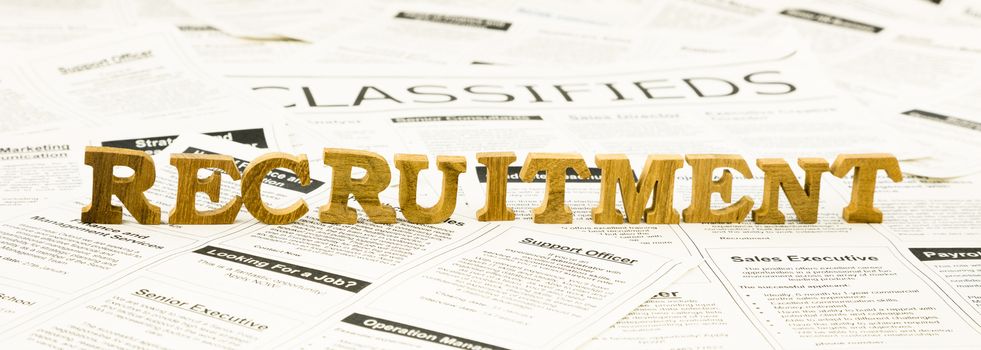 closeup recruitment wording on classifieds ads and newspaper, human resource and employment concepts and ideas