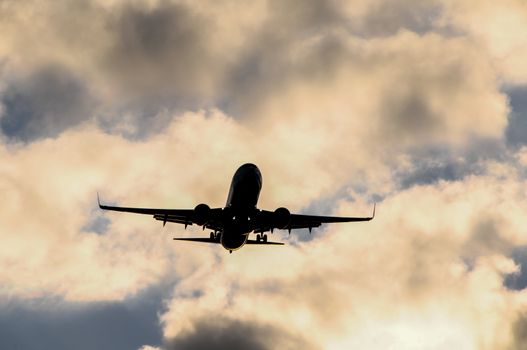 Silhouette of an Airplane Landing over a evening sky