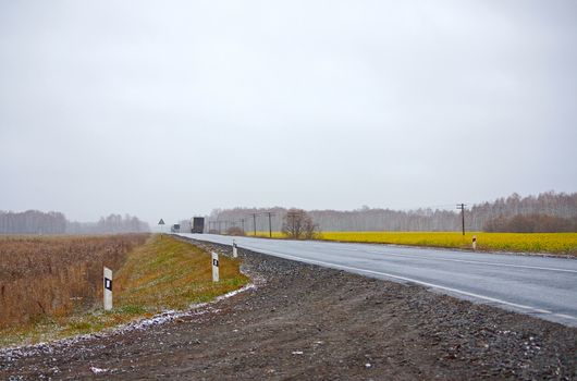 View of  trucks  on winter road against  cloudy sky.