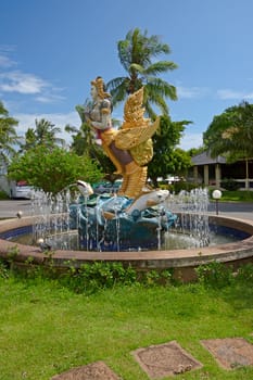 Fountain and sculpture in front of  hotel on a background of blue sky, Thailand.
