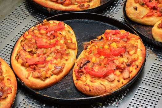 just baked  hot crunchy mini pizzas with cheese and tomato