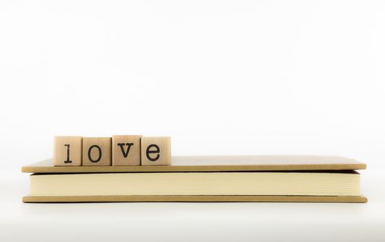 closeup love wording stack on a book, emotion concept and idea