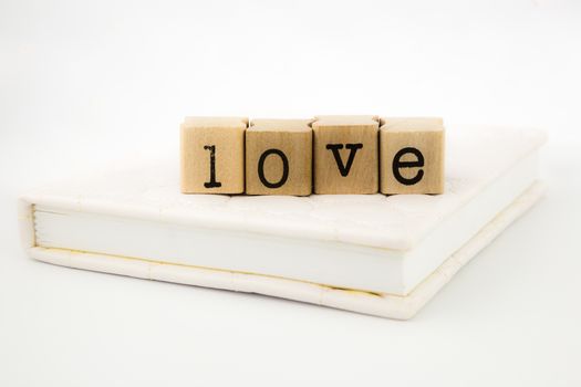 closeup love wording stack on a book, emotion concept and idea