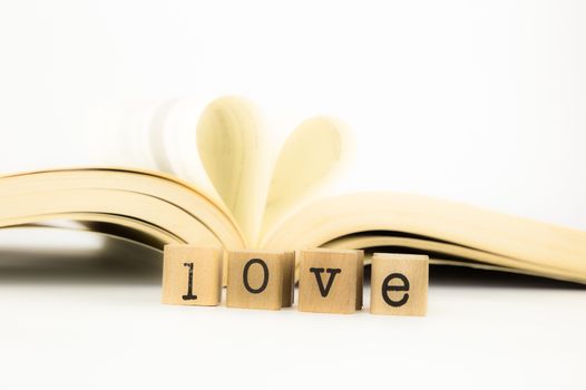 closeup love wording and a book with heart shape, emotion concept and idea