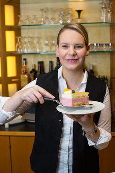 Waitress presenting a piece of cake in cafe