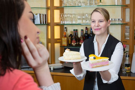 Shopkeeper in confectionery gives client a piece of cake and coffee