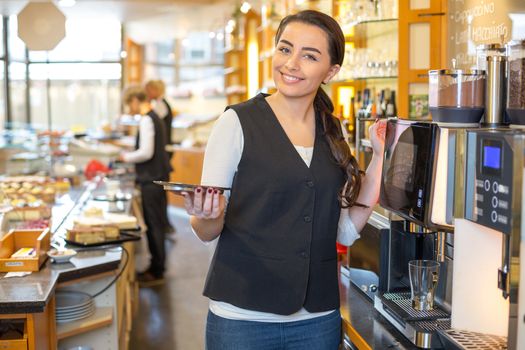 Waitress in cafe or restaurant at coffee machine