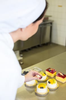 Confectioner preparing cake in bakery or confectionery