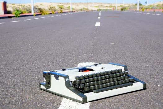 On the Road Writing Concept Typewriter over an Asphalt Street