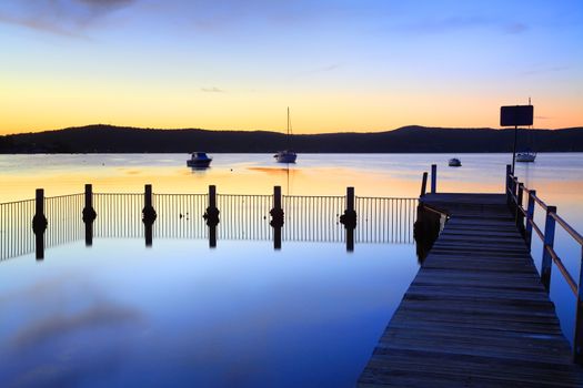 Blue bayou and jetty pool with perfect mirror reflections.  Yattalunga, Australia at dusk