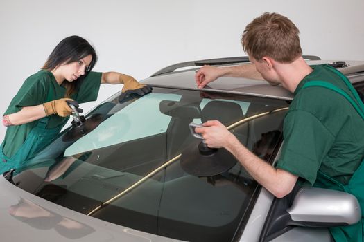 Glazier removing windshield or windscreen on a car