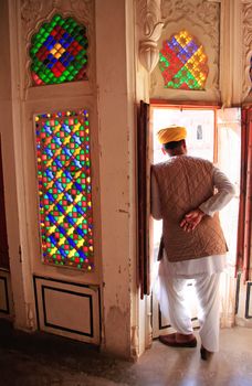 Indian man standing by the doorway at Mehrangarh Fort, Jodhpur, Rajasthan, India