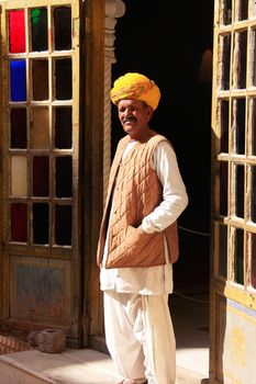 Indian man standing by the doorway at Mehrangarh Fort, Jodhpur, Rajasthan, India