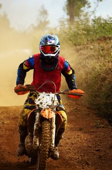 The motorcycle race hole on December at Dambri waterfall, motorcyclist try to speed up goal, red soil way, indistinct dust