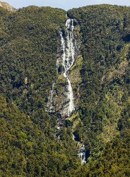 Water cascading down the rock formation in Doubtful Sound on South Island of New Zealand  with multiple waterfalls