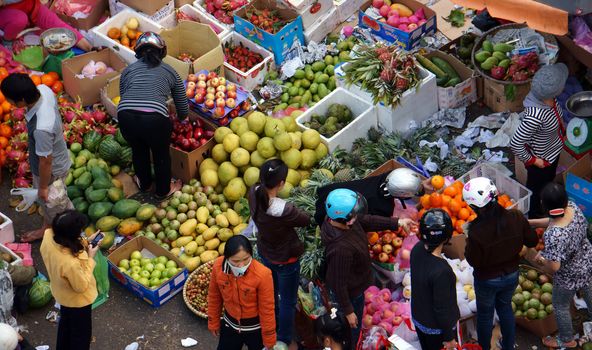 DA LAT, VIET NAM- FEBRUARY 8: People sell and buy fruits at farmers market in  Dalat, Viet Nam- February 8, 2013